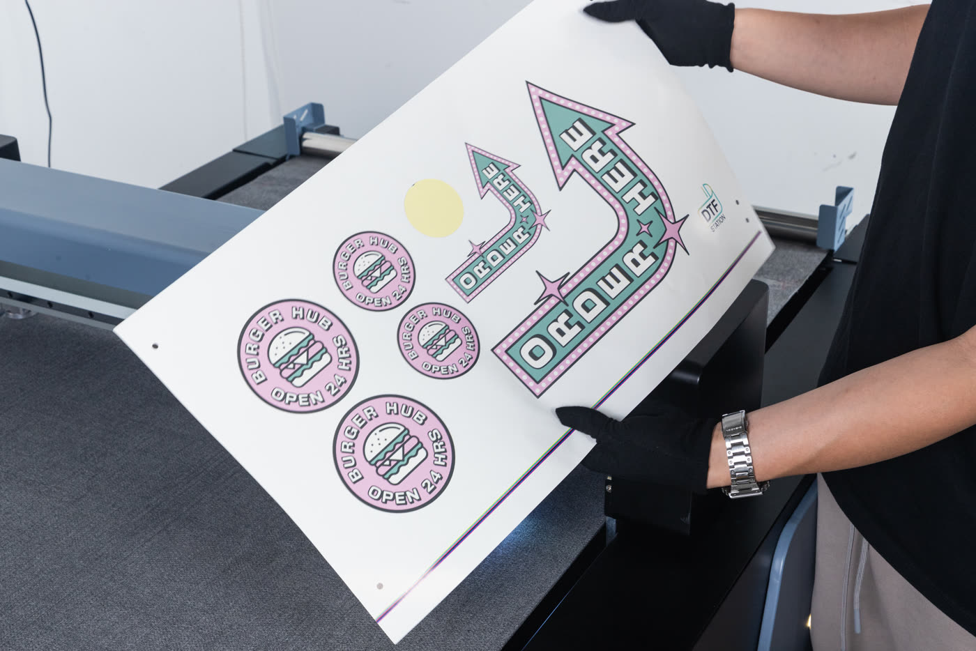 Hands peeling a contour-cut sticker from its backing