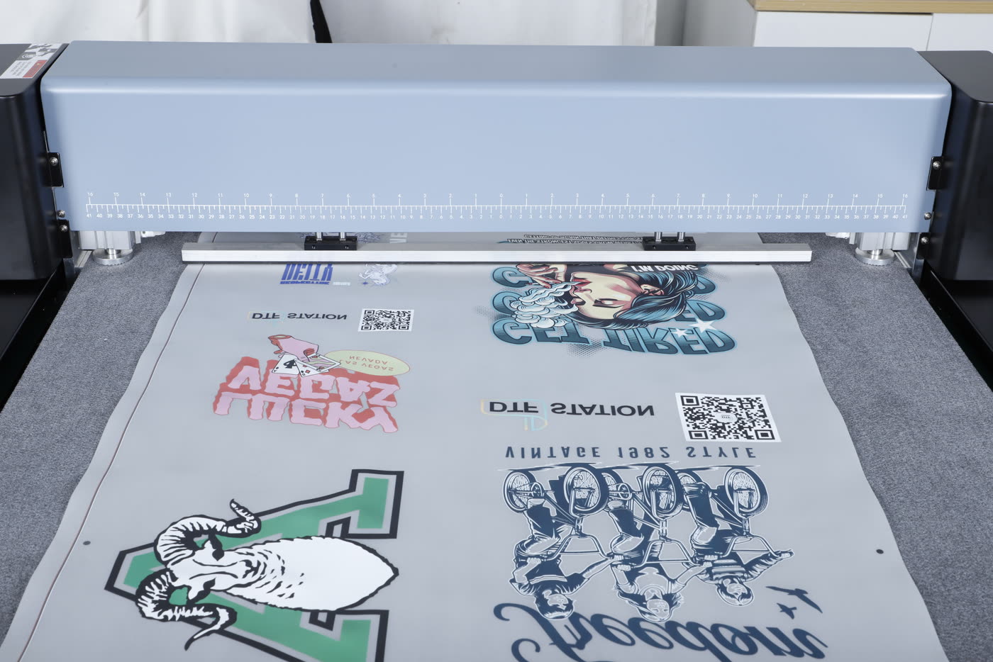A roll of printed DTF film feeding into the Arc 127