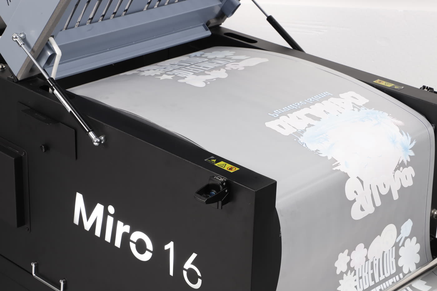 Printed DTF film passing through the Miro 16