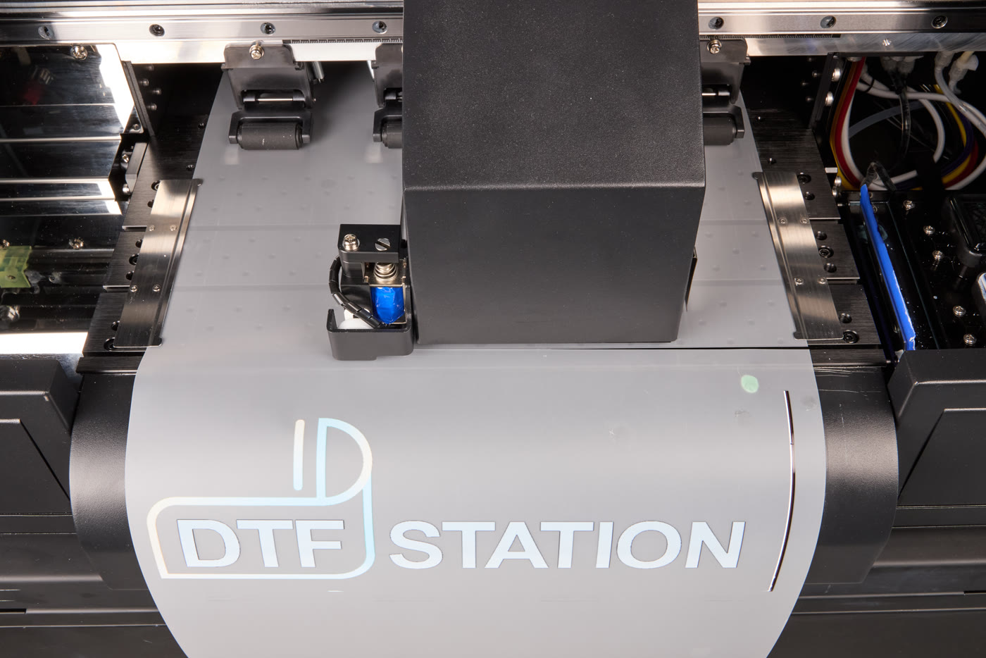 The built-in cutter of the Prestige R2 Pro, over a printed DTF Station film
