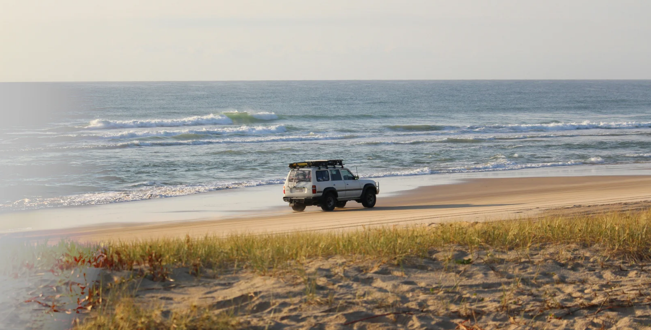 Car driving across sandy beach